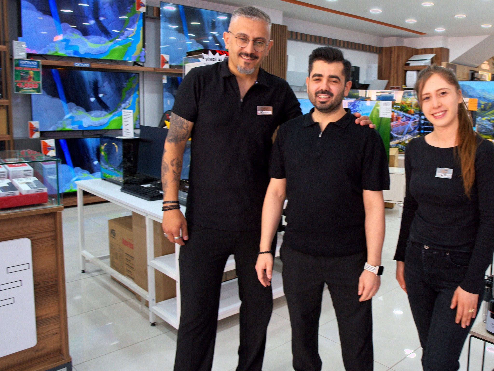 Şube içinde yan yana duran üç Oğuz Ev Concept çalışanı